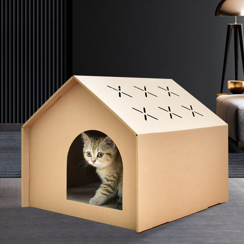 Kat zit in de opening van het kartonnen kattenhuis