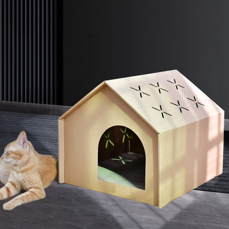 Rode kat ligt naast het kartonnen kattenhuis op een donkere vloer