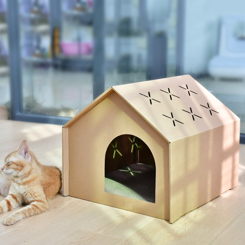 Rode kat ligt naast het kartonnen kattenhuis